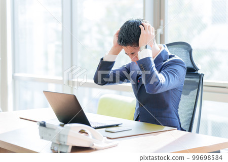 在辦公室裡抱著頭的商人 在辦公室裡抱著頭的商人 99698584
