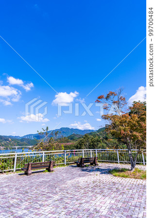 龍門水壩“從休息區和長椅可以看到的龍門水壩周圍的風景”背景是早晨的天空和秋天的樹葉 99700484
