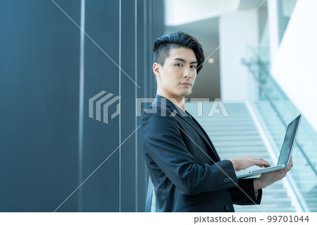 在辦公樓的樓梯上操作個人電腦的年輕商人。攝影合作“LINK FOREST” 在辦公樓的樓梯上操作個人電腦的年輕商人。攝影合作“LINK FOREST” 99701044