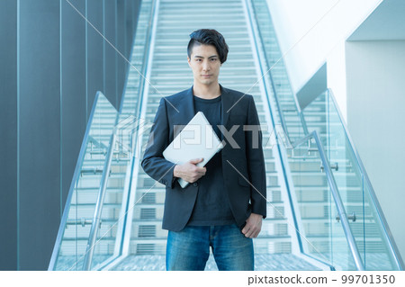寫字樓樓梯前拿著電腦的年輕商人的肖像。攝影合作“LINK FOREST” 寫字樓樓梯前拿著電腦的年輕商人的肖像。攝影合作“LINK FOREST” 99701350