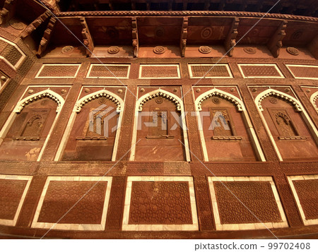 The famous red fort in the city of Agra, India. Tourists visit a popular tourist attraction. 99702408