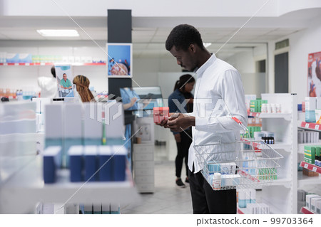 African american man checking prescription heart treatment in drugstore, reading instruction on tablets package. Client choosing vitamins, buying nutritional supplements, side view African american man checking prescription heart treatment in drugstore, reading instruction on tablets package. Client choosing vitamins, buying nutritional supplements, side view 99703364