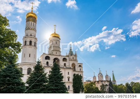 Ivan the Great Bell Tower, with Assumption Belfry on the right in Moscow Kremlin. Blue sky background with sunbeams 99703594
