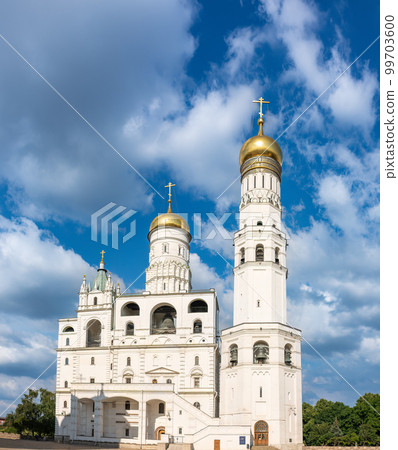 Ivan the Great Bell Tower, with Assumption Belfry on the right in Moscow Kremlin. Blue sky background with sunbeams 99703600