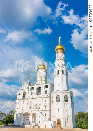 Ivan the Great Bell Tower, with Assumption Belfry on the right in Moscow Kremlin. Blue sky background with sunbeams 99703602