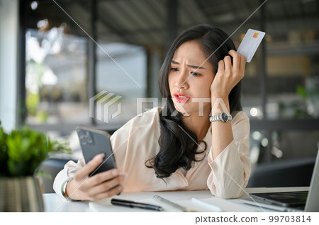 Stressed and furious Asian businesswoman having a problem on her mobile banking service Stressed and furious Asian businesswoman having a problem on her mobile banking service 99703814