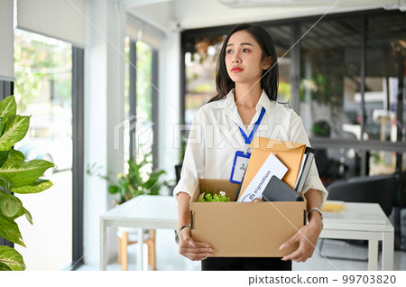 Sad and upset Asian female office worker carrying her belonging, quitting a job, being fired Sad and upset Asian female office worker carrying her belonging, quitting a job, being fired 99703820