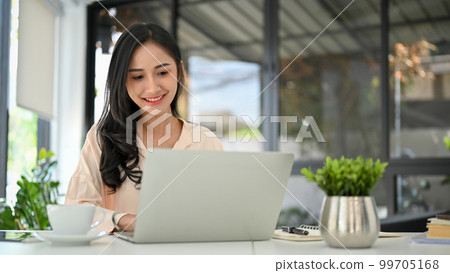 Attractive Asian businesswoman using laptop, working in her modern office. 99705168