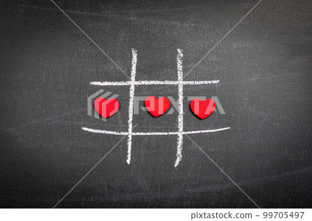 Red hearts in one line on the board. Game of tic tac Red hearts in one line on the board. Game of tic tac 99705497