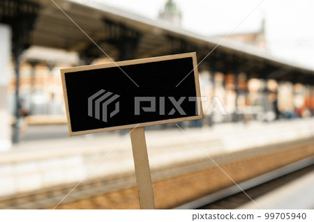 Empty mockup template Blackboard label against defocused background railway station with locomotive. Advertisement Eco Transportation Concept Eco-friendly modes of transport Copy space for text 99705940