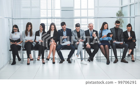 group of business people use their gadgets before starting a business meeting group of business people use their gadgets before starting a business meeting 99706291