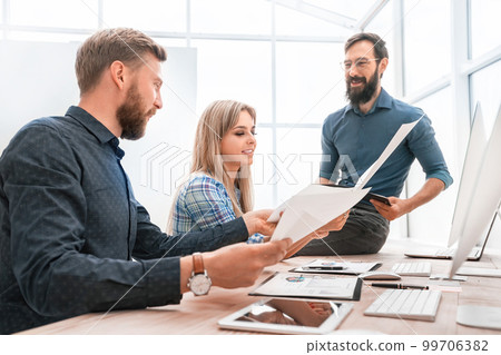 businessman and smiling employees checking financial report. 99706382