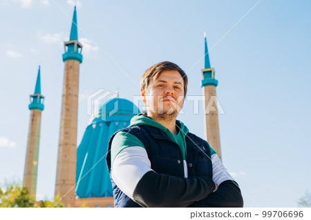 male man against Muslim Mosque. Waist up lifestyle travel portrait of looking at camera european caucasian white young man, religion concept. male man against Muslim Mosque. Waist up lifestyle travel portrait of looking at camera european caucasian white young man, religion concept. 99706696