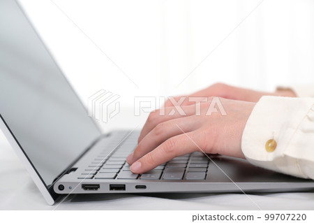 Hands of a woman operating a laptop keyboard Hands of a woman operating a laptop keyboard 99707220