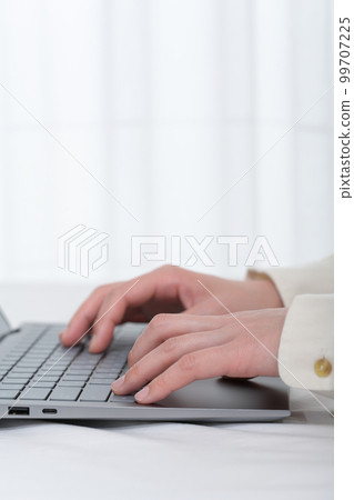 Hands of a woman operating a laptop keyboard 99707225
