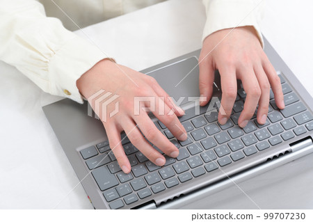 Hands of a woman operating a laptop keyboard 99707230