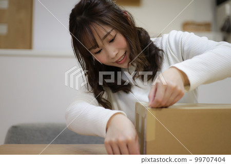 測量紙板箱大小的女人 99707404