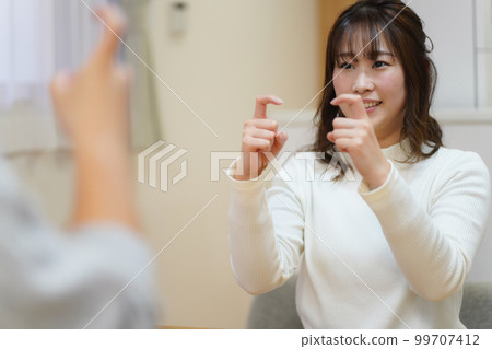 A woman who learns sign language (greetings) 99707412