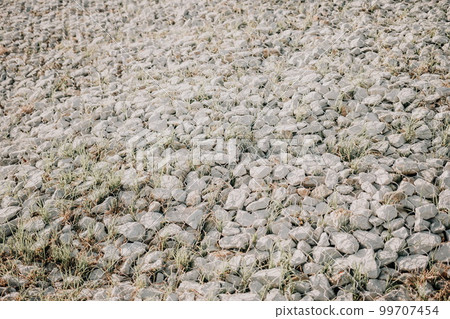 Granite stones behind a metal grate for strengthening the slope. Stones behind the wire. grey texture. construction. Granite stones behind a metal grate for strengthening the slope. Stones behind the wire. grey texture. construction. 99707454