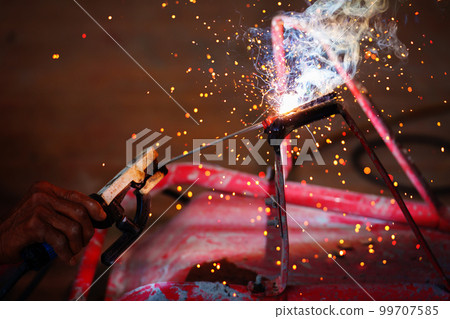 welder working with welding on metal with sparking light 99707585