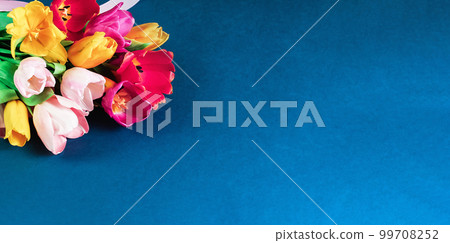 bouquet of fresh red pink yellow tulips on blue. copy space, Birthday gift. Valentines 8 March Women's or Teachers Mothers Day celebration greeting card or minimal banner bouquet of fresh red pink yellow tulips on blue. copy space, Birthday gift. Valentines 8 March Women's or Teachers Mothers Day celebration greeting card or minimal banner 99708252