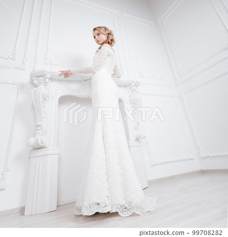 young woman trying on wonderful wedding dress young woman trying on wonderful wedding dress 99708282