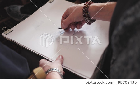 The artist draws a sketch on a piece of paper 99708439