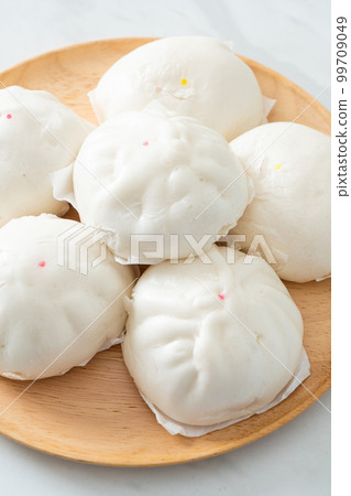 stuffed steamed bun on wood plate 99709049