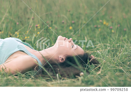 dreaming young woman relaxing on a hot summer day 99709258