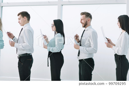 side view.group of employees standing in the office lobby side view.group of employees standing in the office lobby 99709295