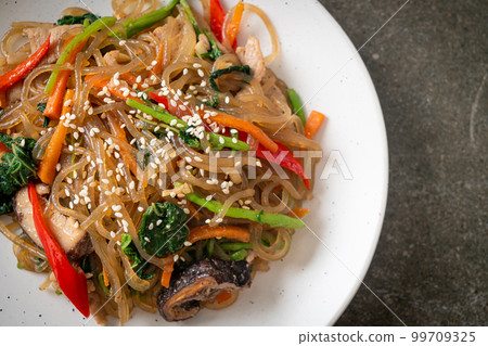 japchae or stir-fried Korean vermicelli noodles with vegetables and pork topped with white sesame 99709325