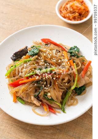 japchae or stir-fried Korean vermicelli noodles with vegetables and pork topped with white sesame 99709337