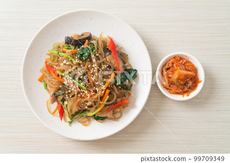 japchae or stir-fried Korean vermicelli noodles with vegetables and pork topped with white sesame 99709349