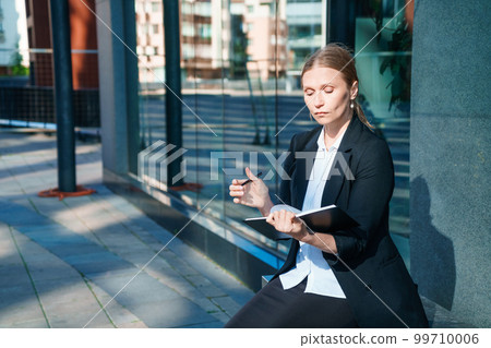 Successful businesswoman taking notes while walking outdoors. Business woman 99710006