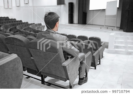 businessman sitting in an empty conference hall businessman sitting in an empty conference hall 99710794