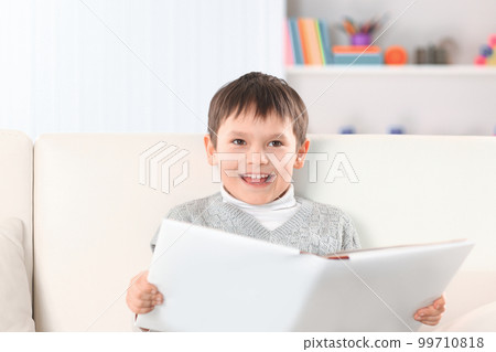 boy reads a book on the couch in the nursery.photo with copy space 99710818