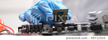 Technician connects a CPU microprocessor to motherboard socket Technician connects a CPU microprocessor to motherboard socket 99712920