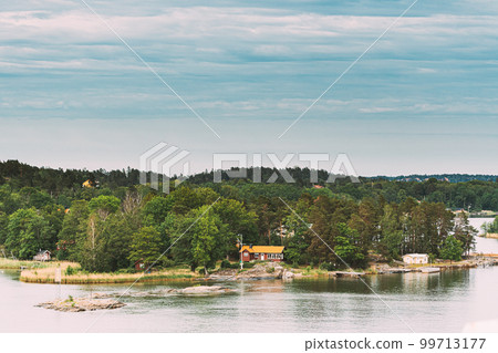 Sweden. Beautiful Swedish Wooden Log Cabins Houses On Rocky Island Coast In Summer Day. Lake Or River Landscape 99713177