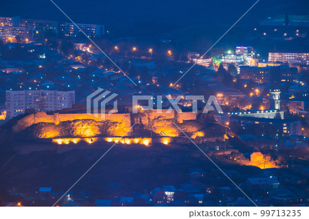 Medieval Citadel In Night Lights. Gori Fortress In Cityscape In Evening Illumination Under Blue Sky. Gori, Shida Kartli Region, Georgia. Travel Destination 99713235