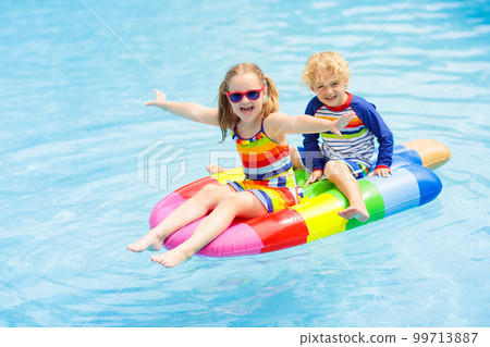 Kids on inflatable float in swimming pool. Kids on inflatable float in swimming pool. 99713887