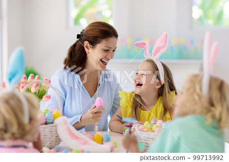 Mother and kids, family coloring Easter eggs. 99713992