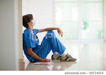 Exhausted tired doctor. Health workers shortage. 99714054