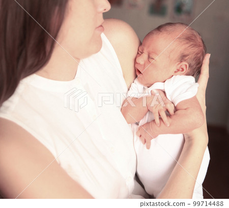 serene newborn baby in his mother's arms serene newborn baby in his mother's arms 99714488