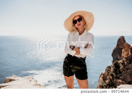 Woman sea hat. Business woman in yellow hat freelancer working over blue sea beach. Girl relieves stress from work. Freelance, digital nomad, travel and holidays concept 99714644