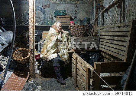 A woman hides in a cellar from shelling 99714815