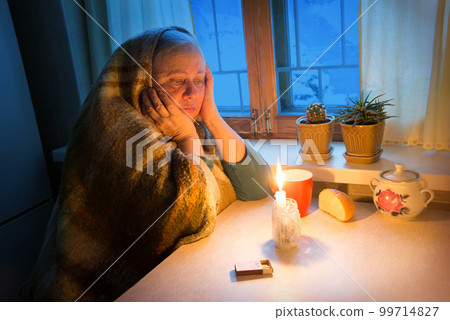 Woman sitting by the window with candles 99714827