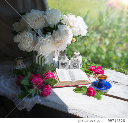 Book and coffee near a bouquet of flowers 99714828