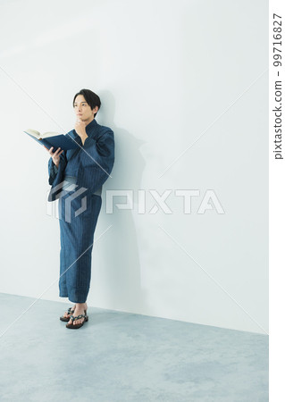 A man in a yukata reading 99716827