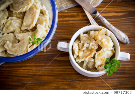 cooked dumplings with potatoes and fried onions on a wooden table. cooked dumplings with potatoes and fried onions on a wooden table. 99717303