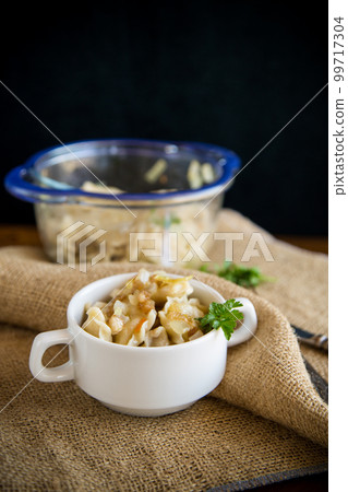 cooked dumplings with potatoes and fried onions on a wooden table. cooked dumplings with potatoes and fried onions on a wooden table. 99717304